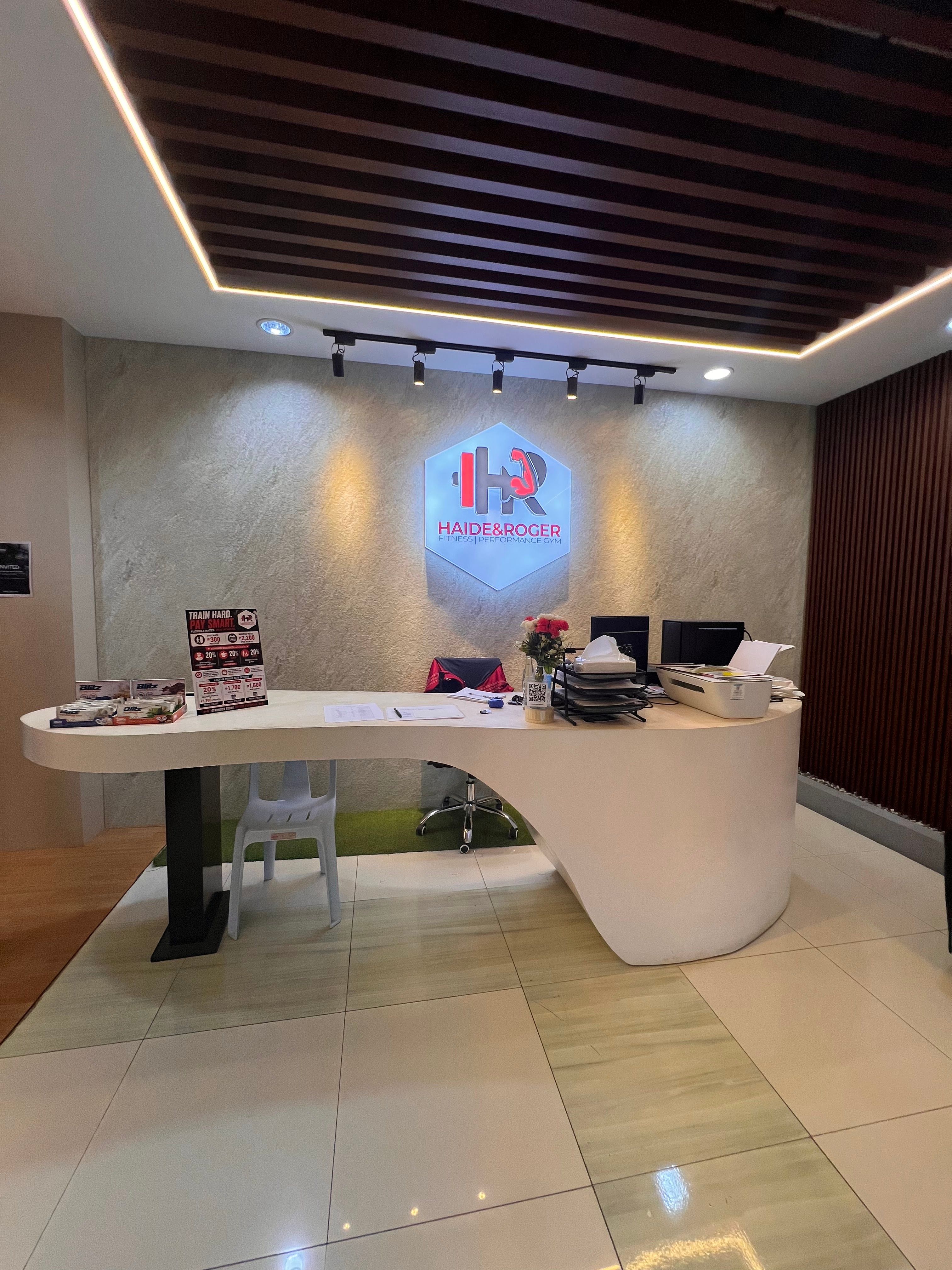 Clean reception desk with the lit H&R logo