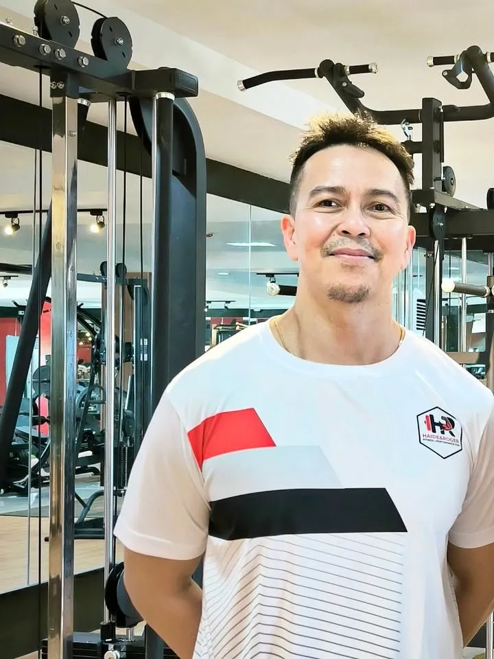 Coach Haide Ejares Jr. in an H&R training shirt on the gym floor