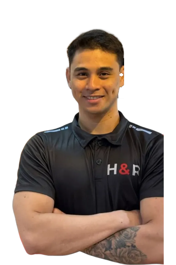 Coach Kenneth smiling with arms crossed in an H&R polo